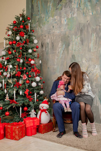 圣诞树附近幸福家庭的肖像。圣诞节冬季快乐和人的概念。