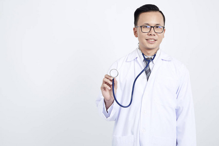 医生在白色背景上拿着听诊器。 亚洲男性模特概念整容手术