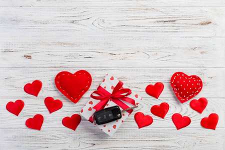 情人节礼物或其他节日手工礼物，纸上红心，汽车钥匙和礼品盒在节日包装。盒子礼物在白色木桌上的顶部视图与复制空间，空空间的设计。