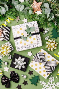 平躺圣诞背景与礼品盒丝带和装饰的绿色和黑色。 平躺式顶部视图