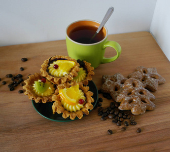 杯子和一壶咖啡和咖啡豆饼干与肉桂在木制桌子上的白色背景。