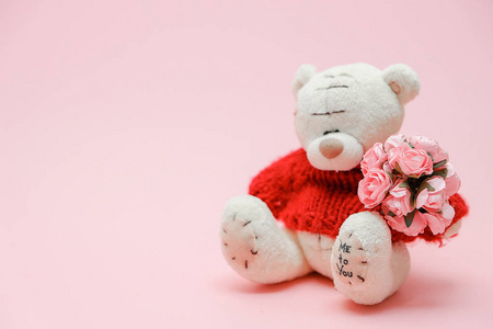情人节背景。可爱的泰迪熊玩具与粉红色的背景花花束。2月14日贺卡