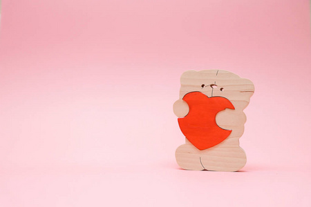情人节背景。可爱的泰迪熊玩具与红色的心脏在粉红色的背景。2月14日贺卡