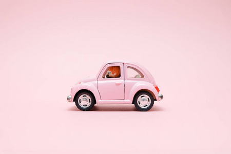 粉红色复古玩具车提供粉红色背景的花束花盒。2月14日情人节卡片。送花。3月8日, 国际妇女节快乐