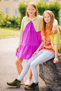 两个穿着五颜六色衣服的有趣的青春期女孩的户外肖像。
