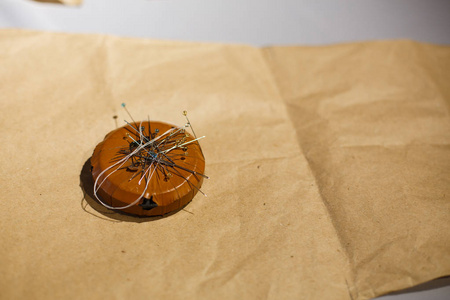 一块带着一束针的磁铁躺在图案上。 缝纫衣服，缝制衣服，裁缝业。