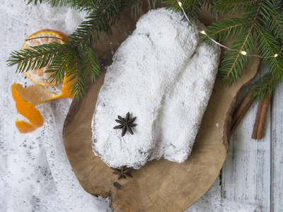 圣诞节在白色背景上用云杉枝和橘子。 传统的圣诞节日糕点甜点。 斯托伦圣诞节。 复制空间选择性聚焦顶部视图