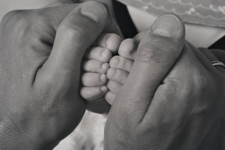 婴儿的脚靠近白色和黑色的背景