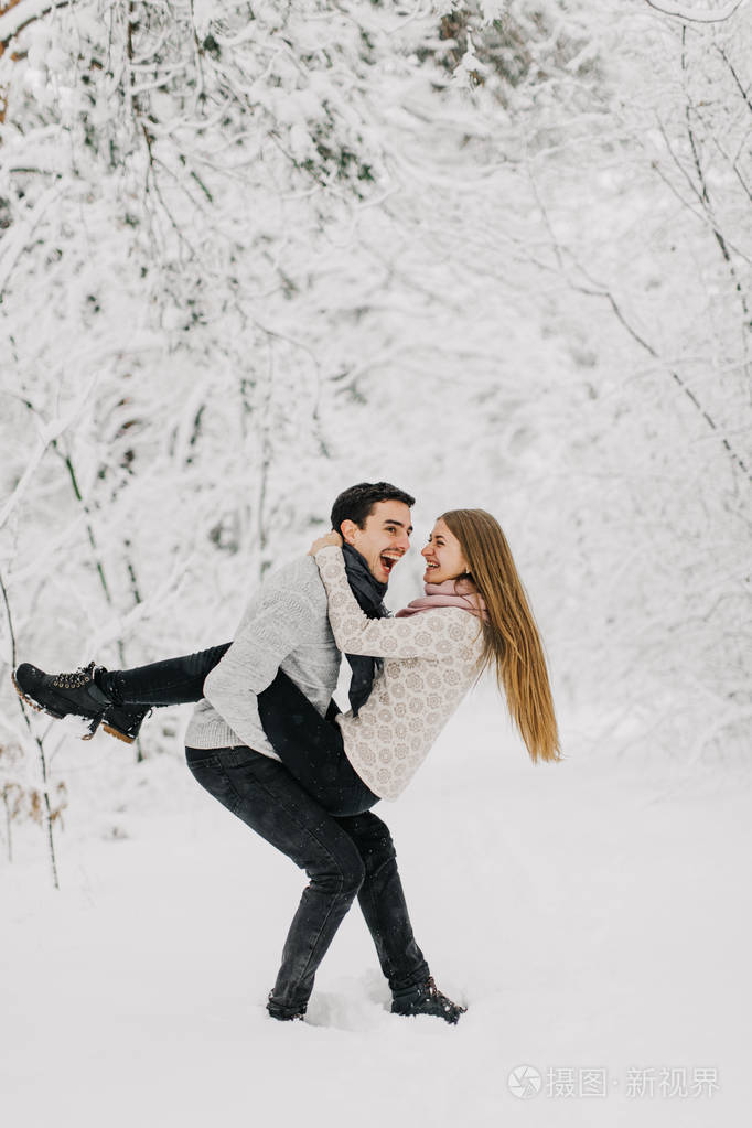 一对相爱的夫妇在雪地森林里拥抱亲吻和享受.