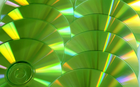 关闭一组绿色和黄色的DVD光盘。 来自彩色光盘的背景。