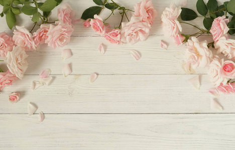 花的背景。 白色木制背景上美丽的粉红色玫瑰花束。俯视。复制空间