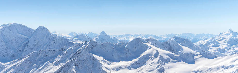 在阳光明媚的日子里, 白雪的冬季高加索山。从滑雪场的全景埃尔布鲁斯, 俄罗斯
