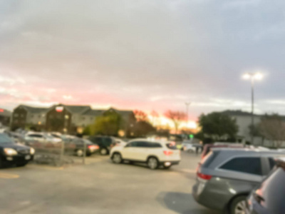 模糊的运动繁忙的停车场附近的一排酒店在戏剧性的日落云下