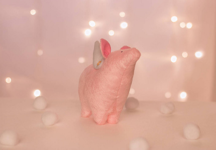 粉红小猪天使与手工翅膀站在背景圣诞灯和球