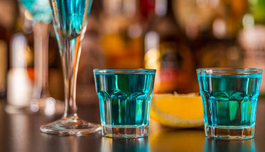 流行的蓝色饮料在酒吧背景上拍摄了神风，瓶瓶罐罐，一个清爽的饮料派对之夜