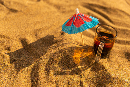 在沙滩上的五颜六色的饮料，带着雨伞喝夏天的放松