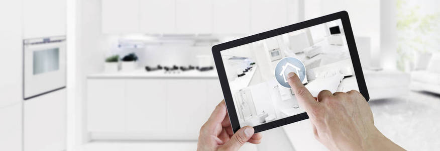 智能家居控制概念手触摸数字平板电脑屏幕与内部客厅，厨房卧室，浴室在模糊的厨房背景网横幅和复制空间模板。