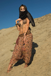 沙漠中的东方女人。 她的身体上覆盖着迈亨迪图案
