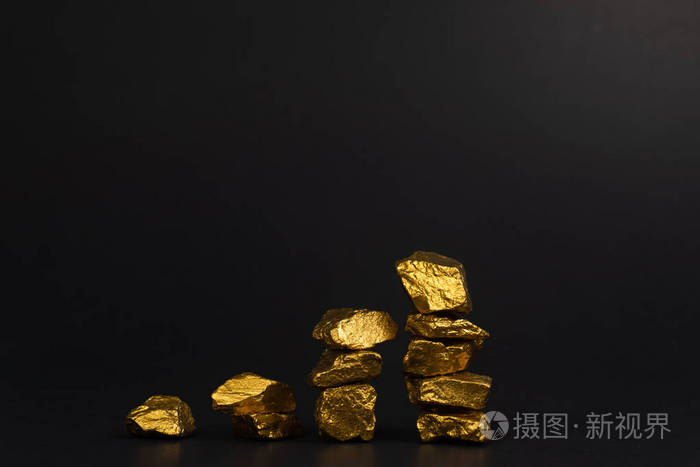 一堆金块或金矿石上的黑色背景宝石或一块金石金融和商业概念.