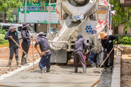 建筑工人浇水泥做道路。