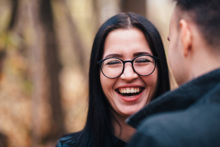 一个年轻的女人和一个男人在秋天的森林里散步的肖像。