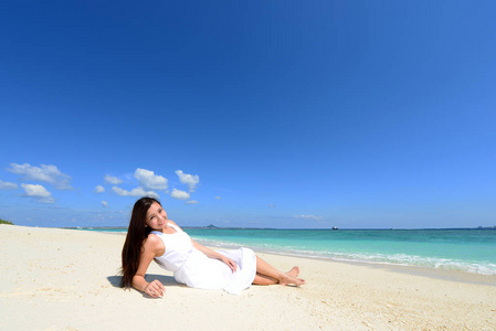 沙滩上的年轻亚洲女人享受阳光图片