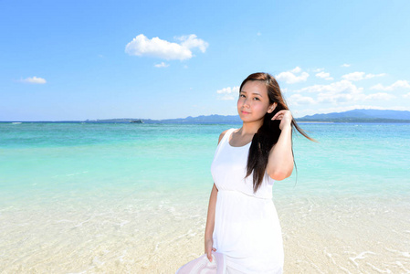沙滩上的年轻亚洲女人享受阳光