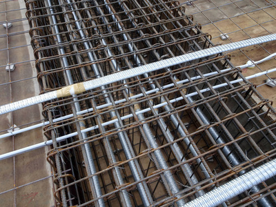 预应力电缆敷设在圆形管道中，并安装在施工现场板钢筋之间。