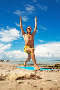 运动的人在海滩上做健身瑜伽运动。用于强度和平衡的 acroyoga 元素