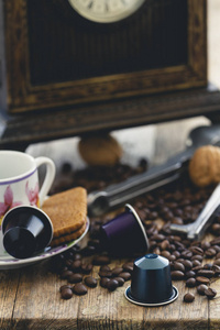 意大利浓咖啡胶囊或咖啡荚与浓咖啡杯和咖啡豆在乡村木材背景。 咖啡配件