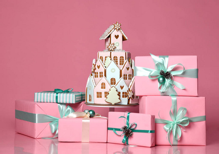 用圣诞饼干做的姜饼屋和粉红色的礼物盒