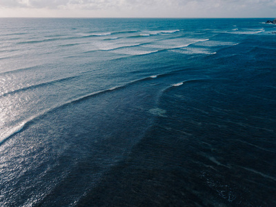 鸟瞰美丽的海浪从无人机。 蓝色海洋水波海面的股票图像图片。 顶部看到绿松石波，清澈的水面纹理。 顶级景观，惊人的自然背景