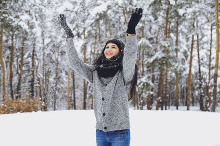 冬雪森林里穿毛衣的年轻美丽的黑发女孩