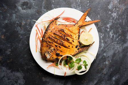 丹多里柚子鱼在粘土烤箱里煮，用柠檬薄荷卷心菜和胡萝卜沙拉装饰。 选择性聚焦