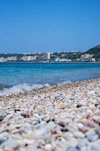 在希腊的罗德岛，一个宁静的海滩景观，蓝色的酒店