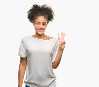 年轻的非洲美国妇女在孤立的背景显示和指着第三个手指，同时微笑自信和快乐。