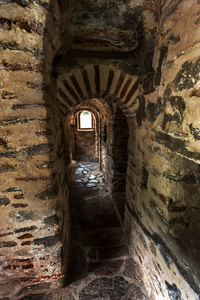 保加利亚的一座中世纪城堡古基督教修道院塔中的一个狭窄的石阶。 神秘阴森的隧道，有石墙