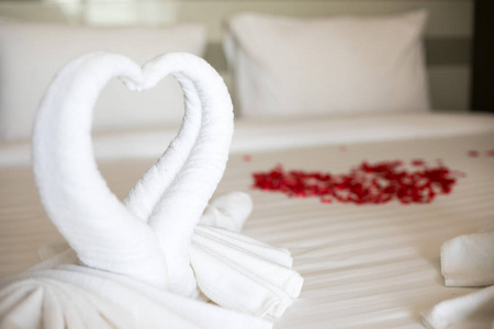 旅馆房间白色床上的心形折叠白色毛巾