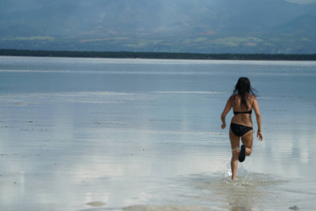穿比基尼的女人在海滩上奔跑的后视镜