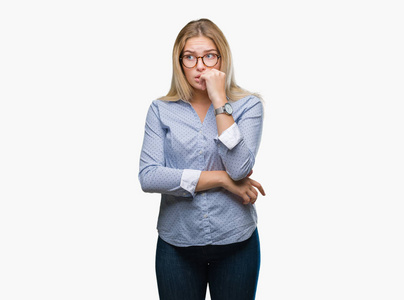 年轻的高加索商务女性戴着眼镜，背景偏僻，看上去压力很大，紧张，双手咬着嘴的指甲。 焦虑问题。