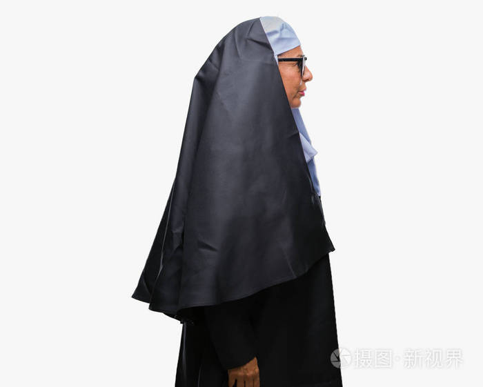 中年资深天主教修女女士戴着太阳镜,在孤立的背景下,看着侧面放松的