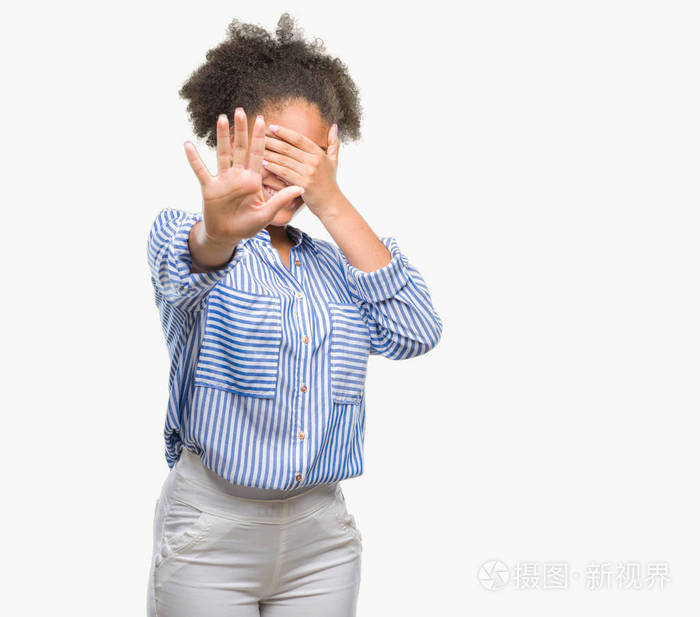年轻的美国黑人妇女在孤立的背景上用手遮住眼睛用悲伤和恐惧的表情做