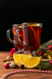 杯中有热辣的覆盖葡萄酒为圣诞节准备的装饰品，放在深色的木桌上