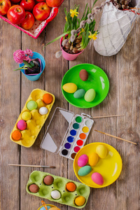 复活节。 一个幸福的家庭将油漆鸡蛋，并准备复活节。 桌面上有油漆和鸡蛋。