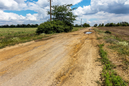 损坏的道路开裂沥青剑与坑坑洼洼和斑点乌克兰。 非常糟糕的沥青道路，有很大的洞。 可怕的技术建设道路。 无数次危险的失败。 糟糕的