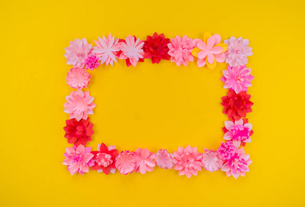 由珊瑚色纸制成的花。卷曲和叶子的粉红色。黄色背景。手工花店。最喜欢的爱好融合贴花。
