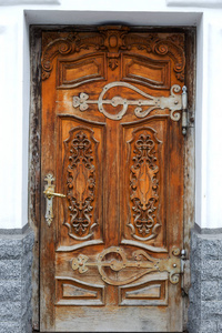 旧木门。 古老的古董木头在一堵旧墙上。 古老的装饰木门。 历史艺术风格的门面，精英昂贵的古董门。 木制背景旧前门复古元素