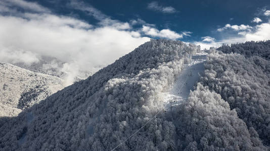缆车到雪山的顶部。 克拉斯纳亚多亚纳契冬季的雪。 用复印机进行空中摄影。 白雪覆盖的山脉。 在山上野营度假。