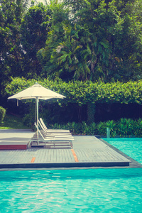 酒店和度假胜地游泳池周围的漂亮豪华雨伞和椅子，供旅行和度假用
