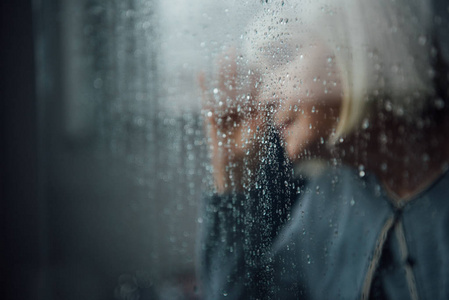 窗外飘着雨滴模糊的孤独老人的画像